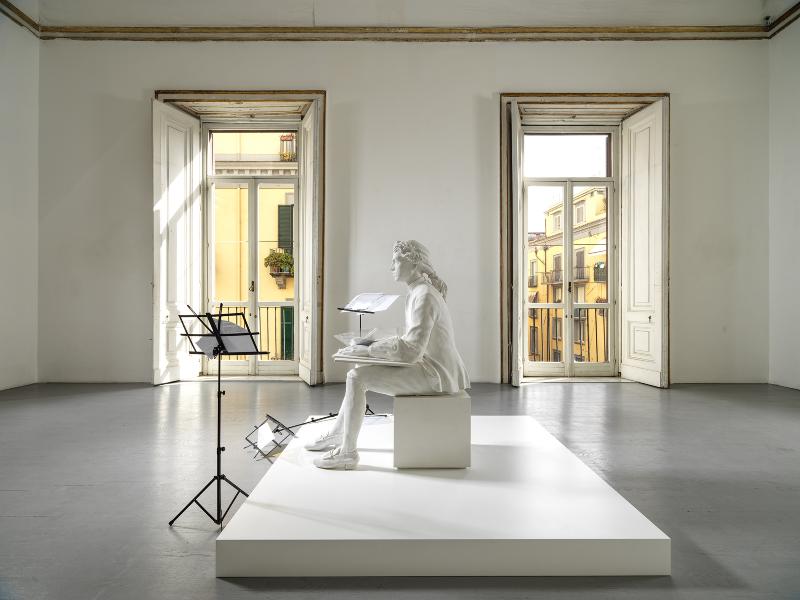 Firmamento, 2024, plaster cast, reproductions on acetate, lecterns, white wooden platform, cast h 130 cm, sheets of acetate 29.7 x 42 cm each, platform 15 x 185 x 185 cm, h 153 x 235 x 224 cm overall dimensions 